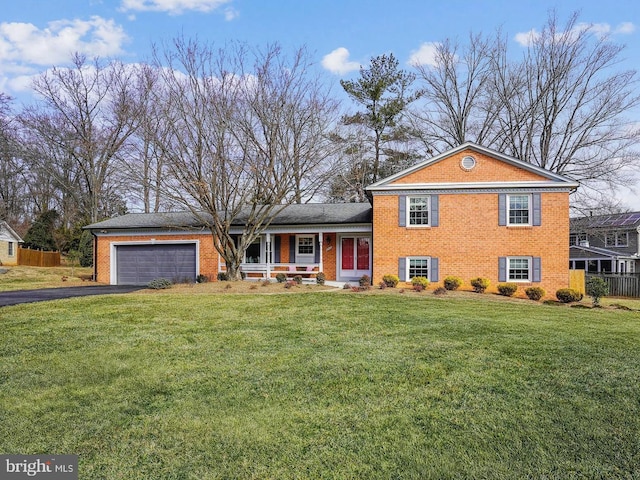 tri-level home featuring an attached garage, brick siding, driveway, and a front lawn