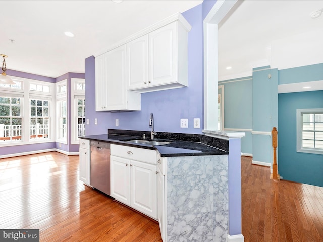 kitchen with sink, light wood-type flooring, white cabinetry, dishwasher, and kitchen peninsula