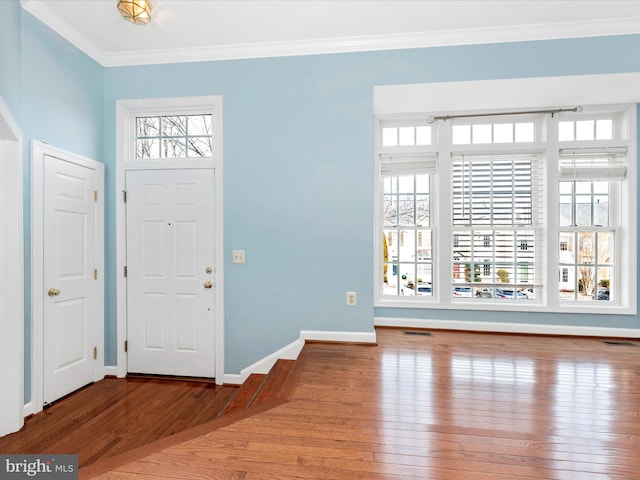 foyer entrance with ornamental molding and hardwood / wood-style flooring