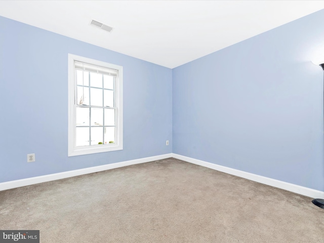 spare room featuring light colored carpet