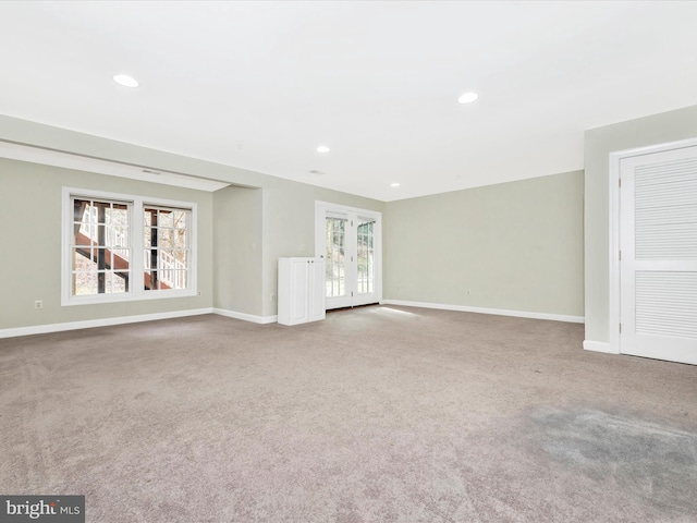 unfurnished living room featuring french doors and carpet flooring