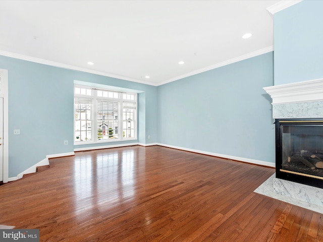 unfurnished living room featuring hardwood / wood-style floors, a premium fireplace, and ornamental molding