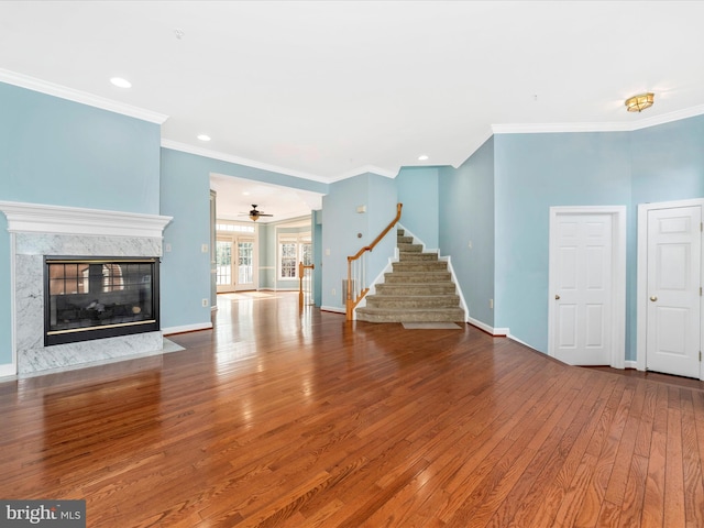 unfurnished living room with ornamental molding, a high end fireplace, and wood-type flooring