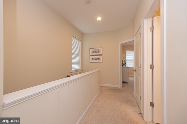 hallway featuring light carpet, baseboards, and recessed lighting