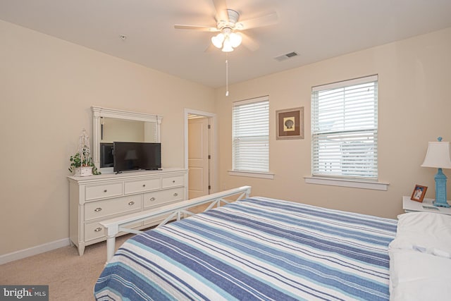 bedroom with a ceiling fan, light carpet, visible vents, and baseboards