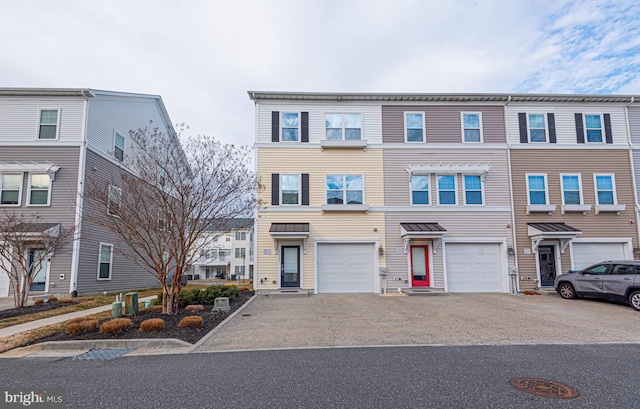 townhome / multi-family property featuring driveway and an attached garage