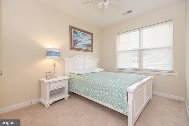 bedroom featuring baseboards, a ceiling fan, visible vents, and light colored carpet