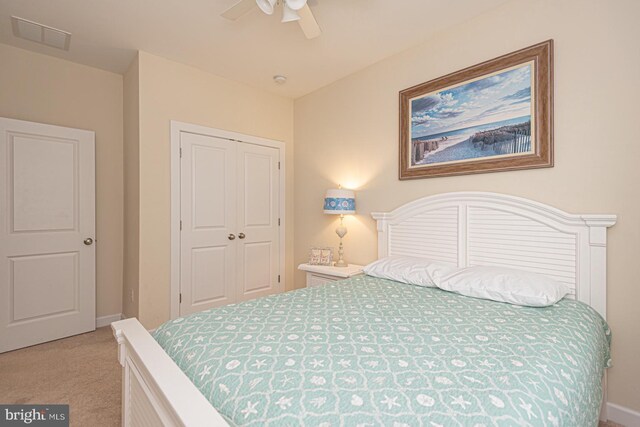 bedroom with light carpet, visible vents, baseboards, a ceiling fan, and a closet