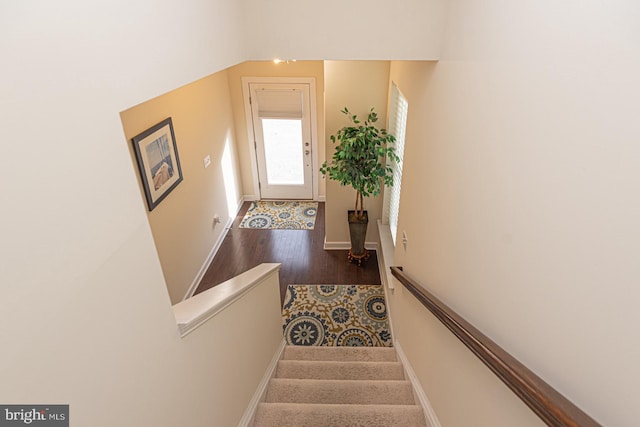 staircase with baseboards and wood finished floors