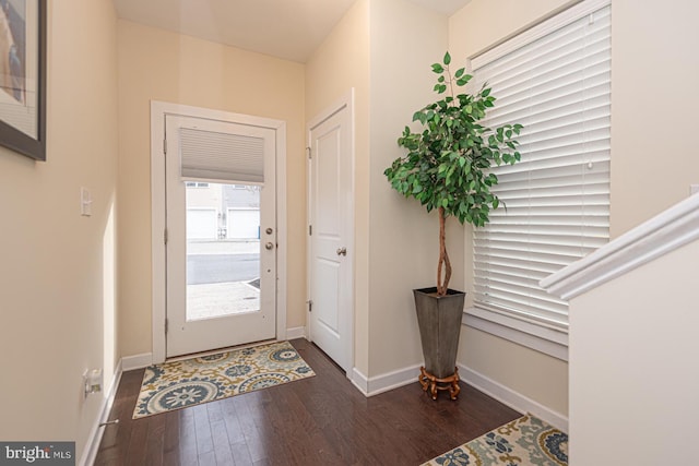 foyer featuring dark wood-style flooring and baseboards