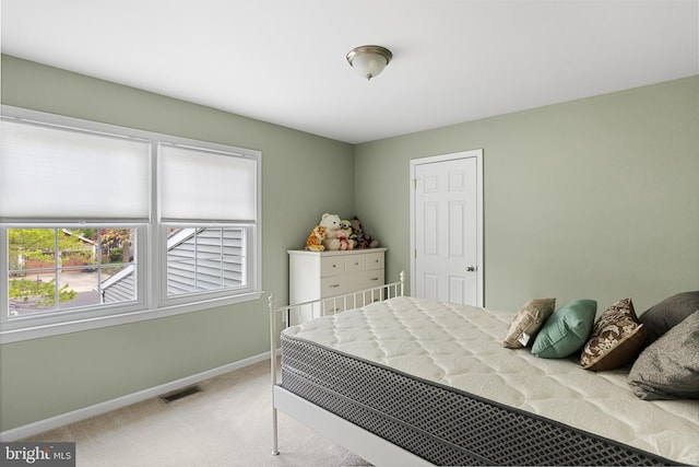 bedroom with light carpet, visible vents, and baseboards