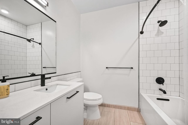 full bathroom with baseboards, tub / shower combination, vanity, and toilet