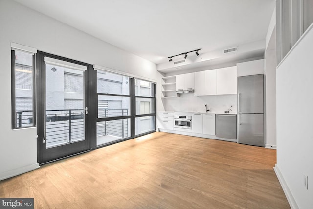 kitchen featuring white cabinets, modern cabinets, stainless steel appliances, light countertops, and open shelves