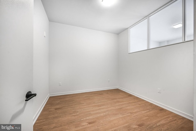 spare room with light wood-type flooring and baseboards