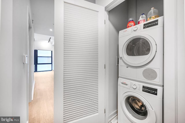 laundry room featuring stacked washer / dryer, laundry area, and wood finished floors