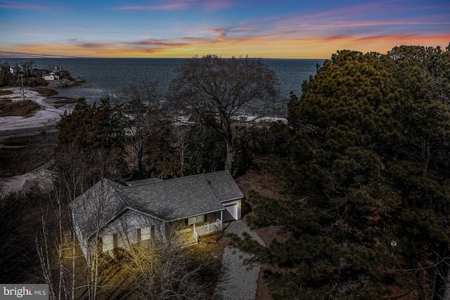 aerial view at dusk featuring a water view