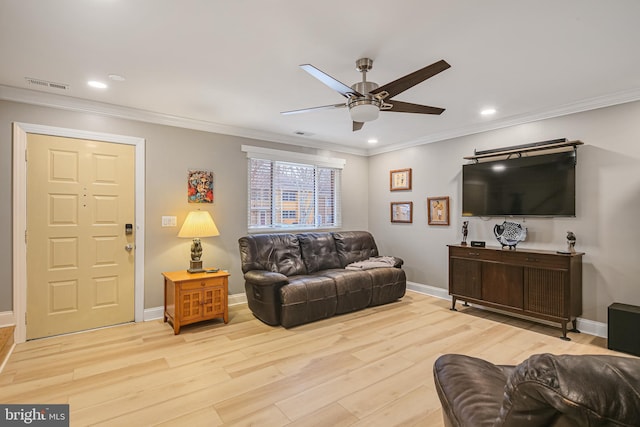 living room with light wood-style floors, baseboards, visible vents, and ornamental molding