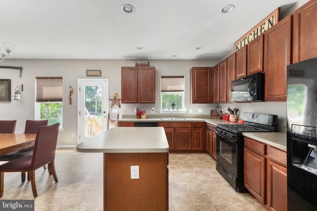 kitchen with recessed lighting, a center island, light countertops, brown cabinets, and black appliances