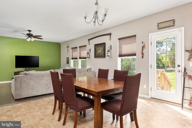 dining room with a wealth of natural light, baseboards, and ceiling fan with notable chandelier