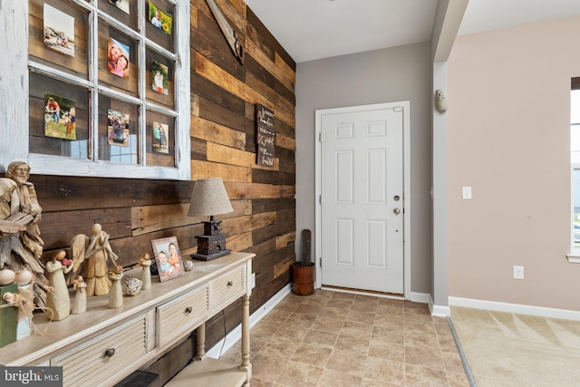 foyer entrance featuring wooden walls and baseboards