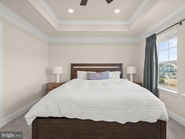 bedroom with a tray ceiling, carpet, crown molding, and baseboards