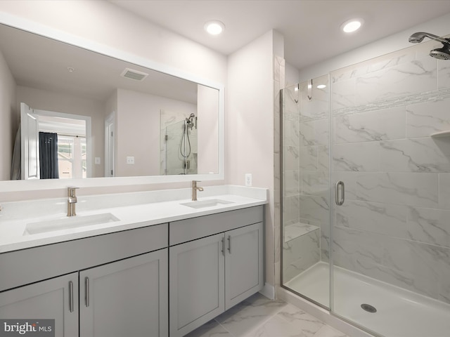 bathroom featuring marble finish floor, a marble finish shower, a sink, and visible vents