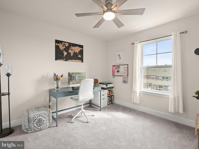 carpeted office space with baseboards and a ceiling fan