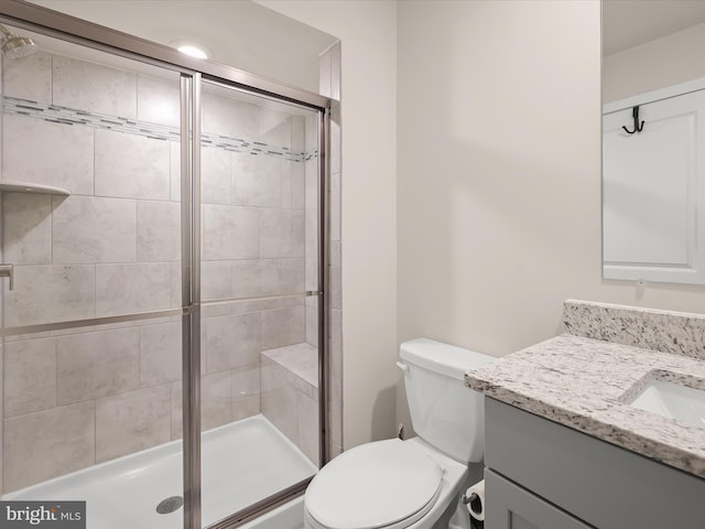 bathroom featuring a stall shower, vanity, and toilet