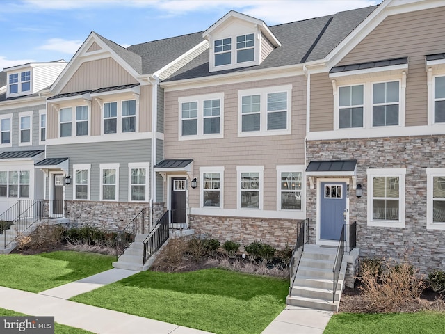 townhome / multi-family property featuring a standing seam roof, stone siding, and metal roof