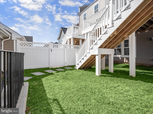 view of yard with a fenced backyard and stairway