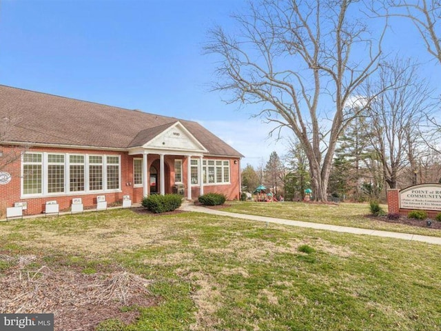 view of front of house with a front lawn and brick siding