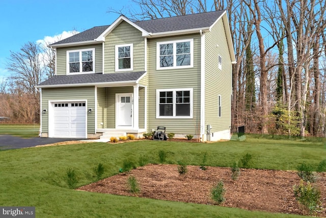 view of front of house featuring an attached garage, aphalt driveway, a front lawn, and roof with shingles