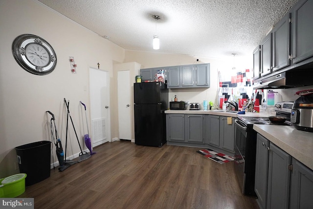 kitchen with lofted ceiling, dark wood-type flooring, light countertops, gray cabinetry, and black appliances