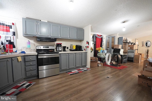 kitchen featuring dark wood-type flooring, stainless steel electric range, gray cabinets, light countertops, and under cabinet range hood