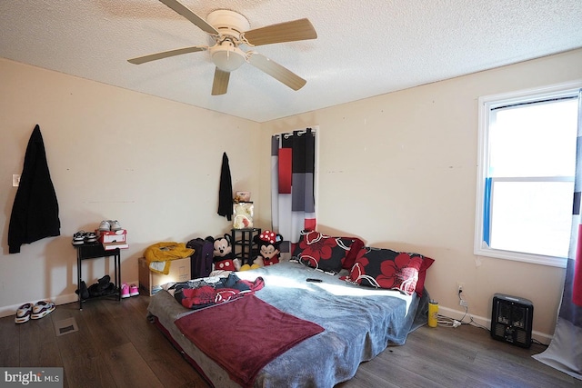 bedroom featuring baseboards, a textured ceiling, a ceiling fan, and wood finished floors