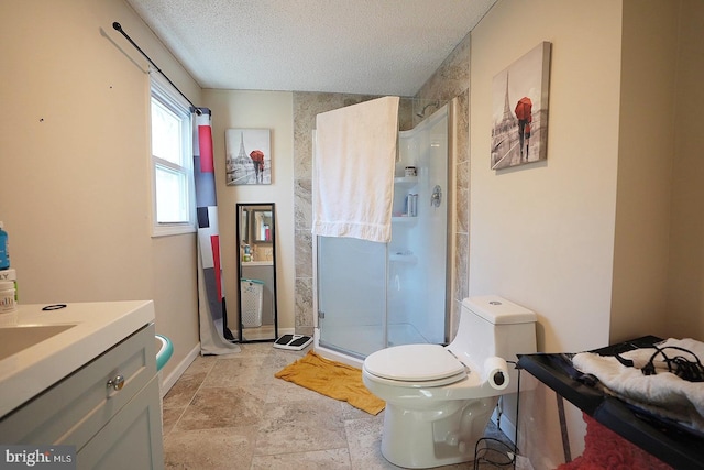 bathroom with toilet, a stall shower, a textured ceiling, vanity, and baseboards