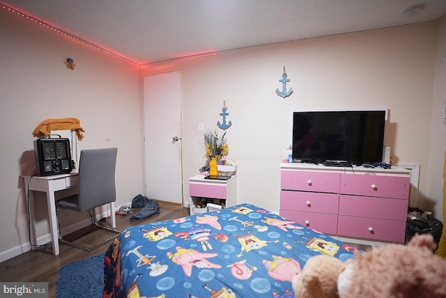 bedroom with dark wood finished floors and baseboards