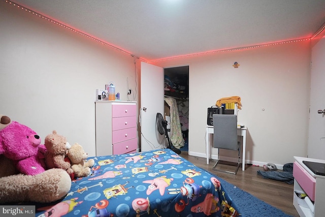 bedroom featuring a closet, baseboards, and dark wood-type flooring