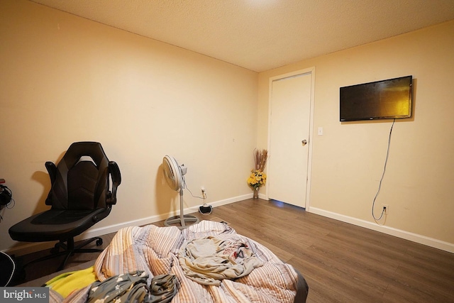 interior space featuring a textured ceiling, dark wood-style flooring, and baseboards