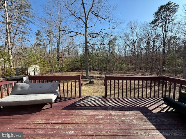 wooden deck featuring an outbuilding and a shed