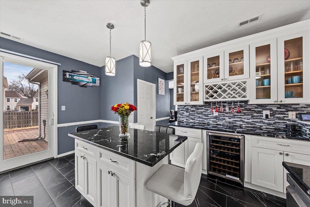 kitchen with beverage cooler, visible vents, glass insert cabinets, and white cabinets