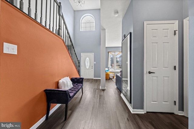 foyer entrance featuring baseboards, stairway, dark wood-style flooring, and a healthy amount of sunlight