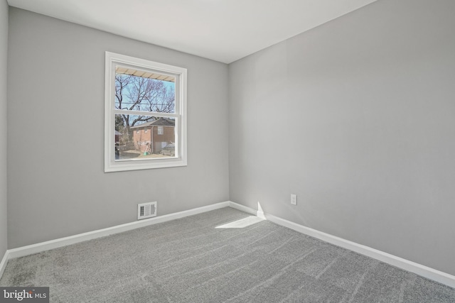 carpeted empty room with visible vents and baseboards