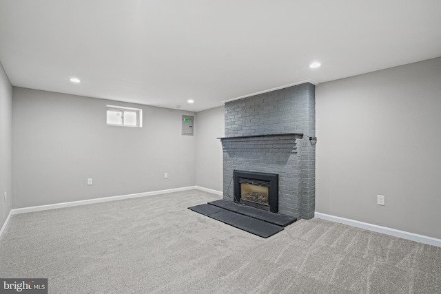 unfurnished living room featuring light carpet, a brick fireplace, baseboards, and recessed lighting