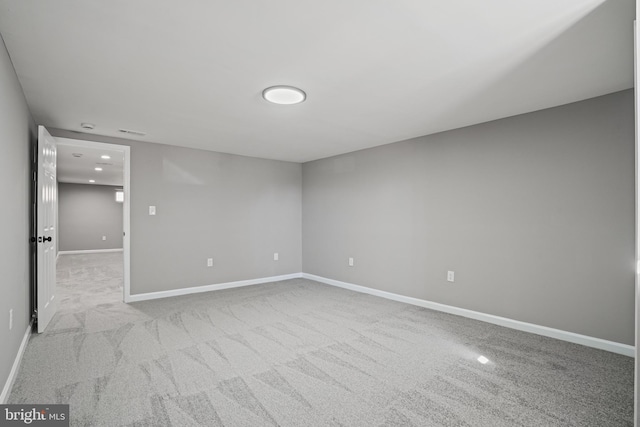 spare room with recessed lighting, light colored carpet, visible vents, and baseboards