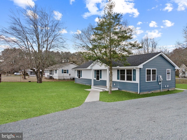 ranch-style home with a shingled roof, driveway, and a front lawn