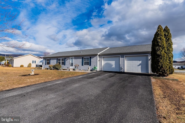 ranch-style house with aphalt driveway, a front lawn, and an attached garage