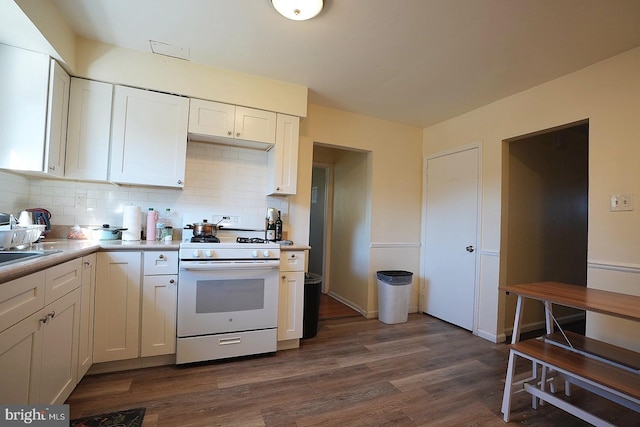 kitchen with light countertops, white gas range, dark wood finished floors, and white cabinets