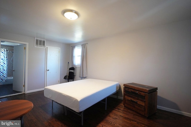 bedroom with dark wood-type flooring, visible vents, and baseboards