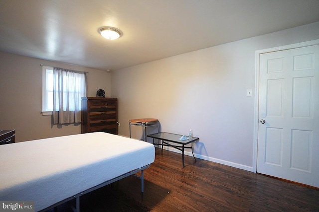 bedroom with dark wood-style flooring and baseboards